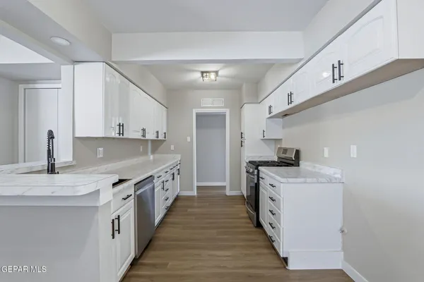 a kitchen with a sink stove top oven and cabinets