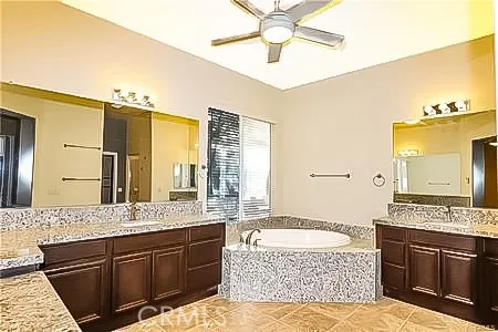 a spacious bathroom with a granite countertop tub sink and mirror