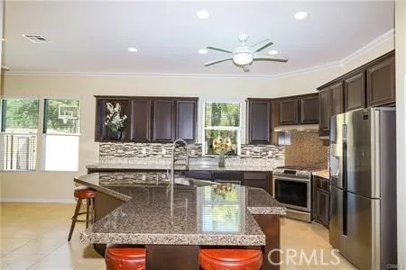 a kitchen with kitchen island granite countertop a sink stainless steel appliances and cabinets