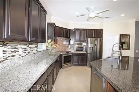 a kitchen with granite countertop a sink a counter top space appliances and cabinets