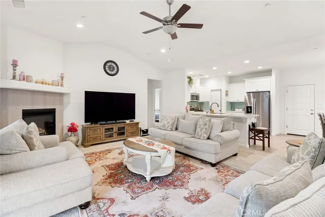 a living room with furniture a flat screen tv and a fireplace