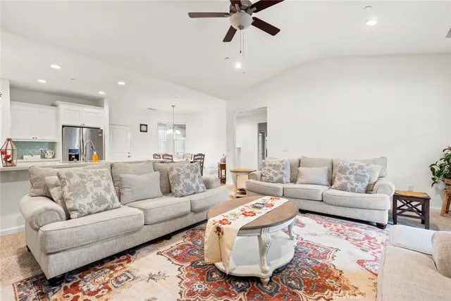a living room with furniture and a view of kitchen