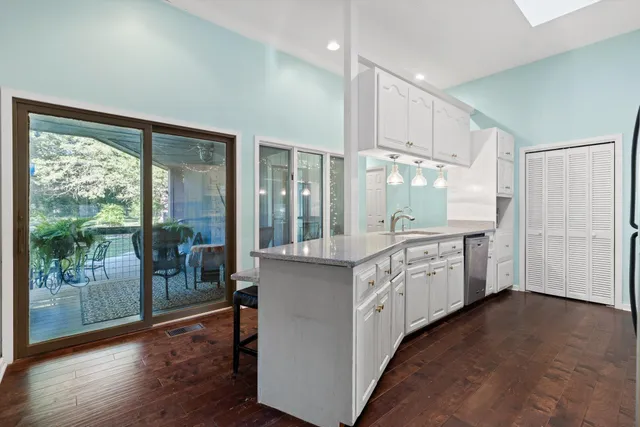 a kitchen with granite countertop white cabinets and wooden floor