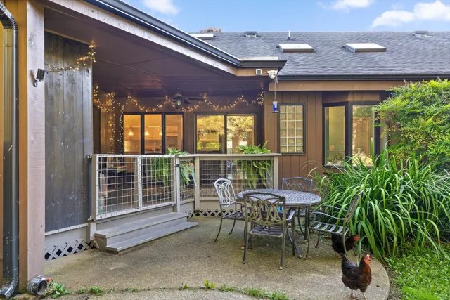 a patio with table and chairs and potted plants