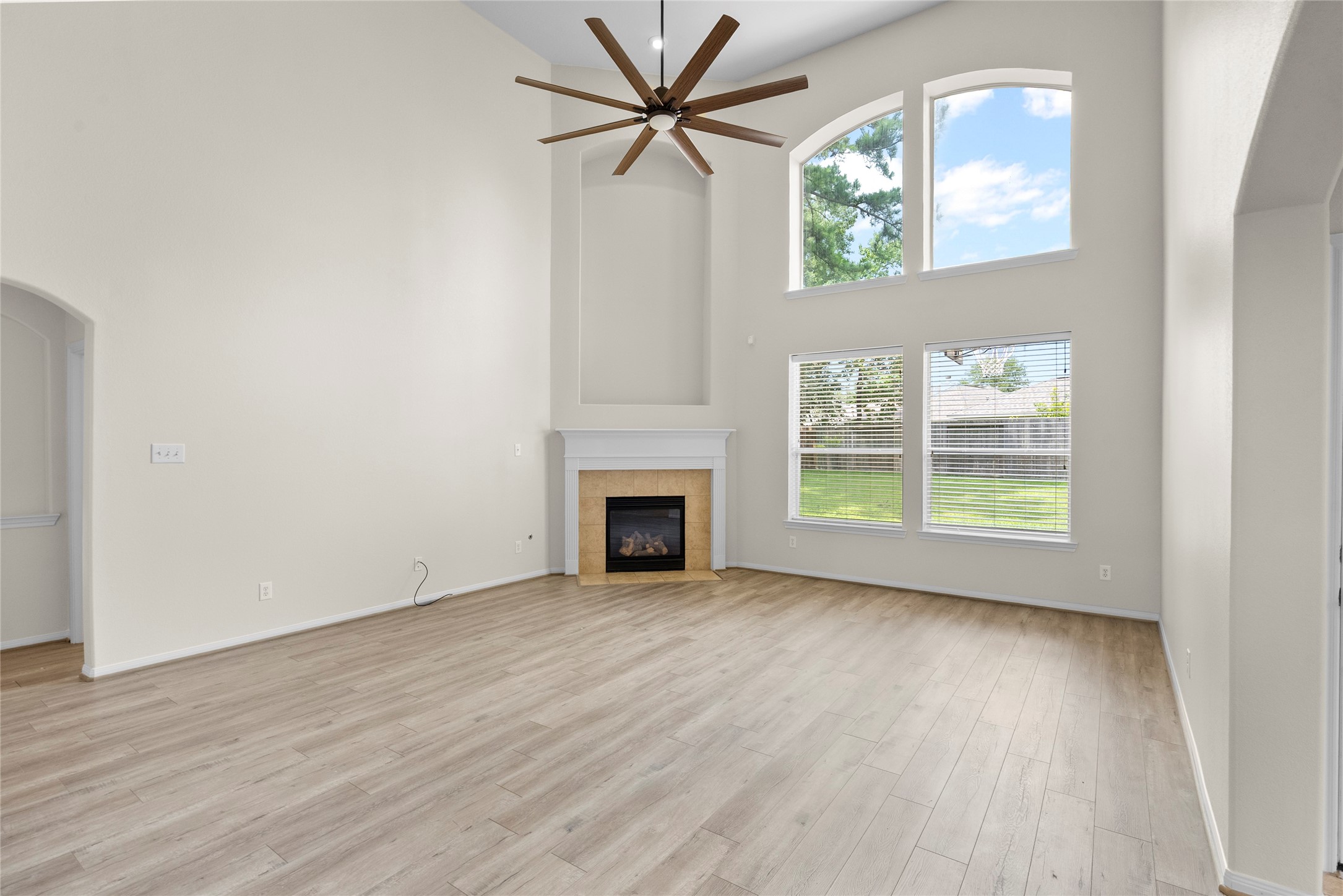 6407 Pine Rest Drive Spring, TX 77389 - Photo 11 of 26 an empty room with windows fireplace and a chandelier fan