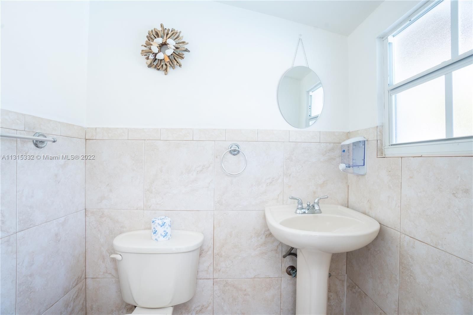 9215 Southwest 45th Street, Unit 9215 Miami, FL 33165 - Photo 11 of 37 a bathroom with a sink mirror and toilet