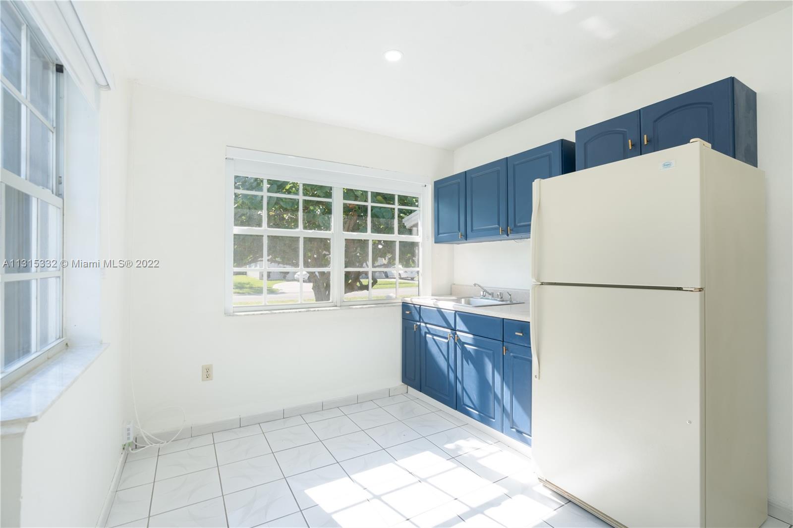 9215 Southwest 45th Street, Unit 9215 Miami, FL 33165 - Photo 21 of 37 a kitchen with a refrigerator sink washer and cabinets