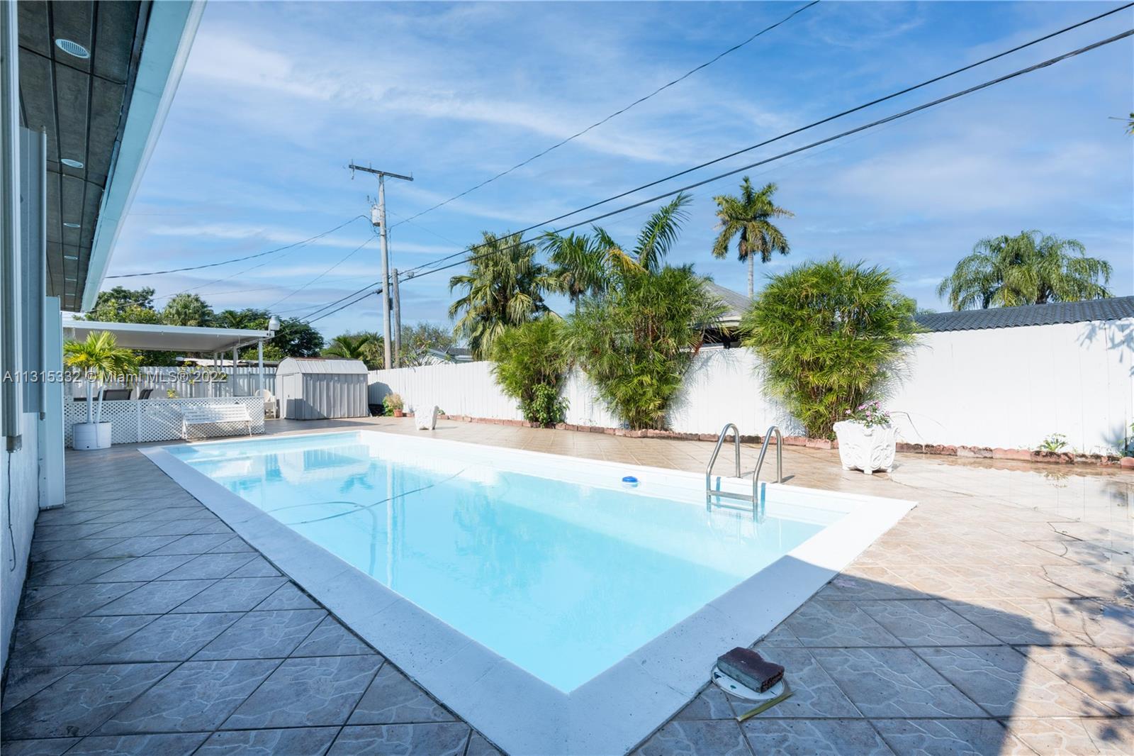 9215 Southwest 45th Street, Unit 9215 Miami, FL 33165 - Photo 22 of 37 a view of swimming pool with outdoor seating and plants