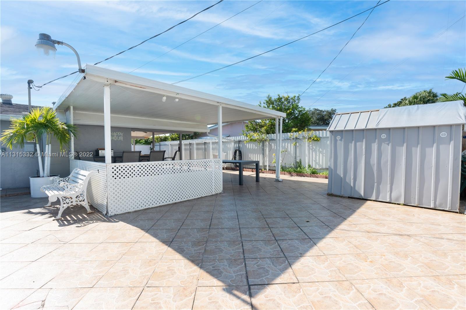 9215 Southwest 45th Street, Unit 9215 Miami, FL 33165 - Photo 30 of 37 a view of a patio with table and chairs with wooden fence