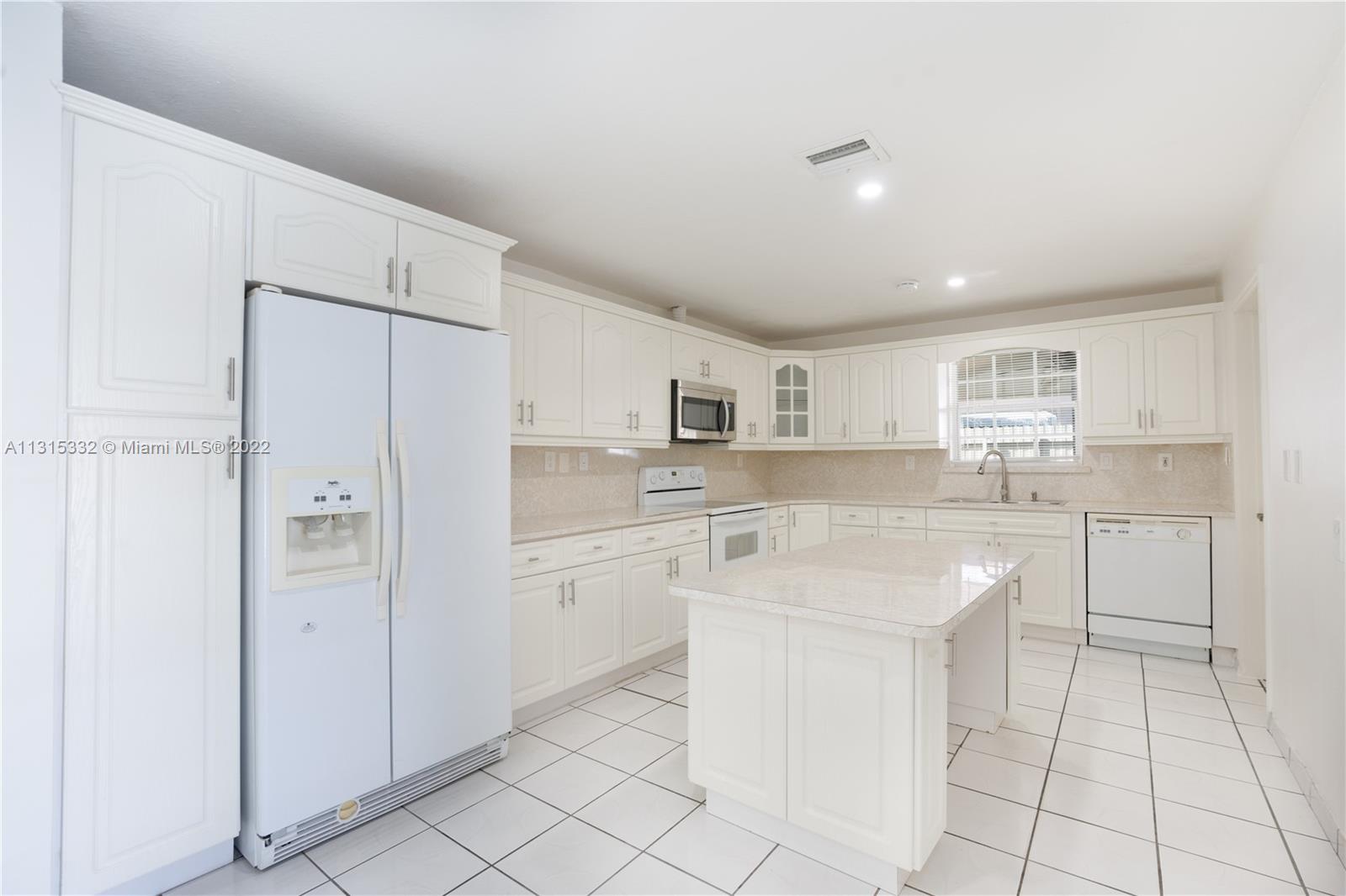 9215 Southwest 45th Street, Unit 9215 Miami, FL 33165 - Photo 7 of 37 a kitchen with white cabinets and sink