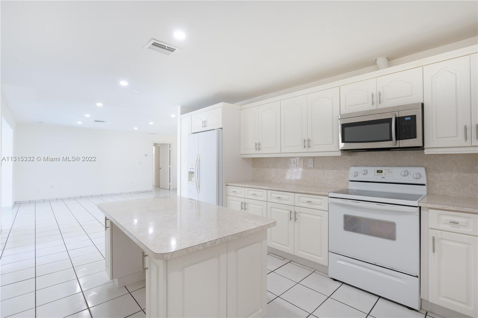 9215 Southwest 45th Street, Unit 9215 Miami, FL 33165 - Photo 8 of 37 a kitchen with a sink stainless steel appliances and white cabinets