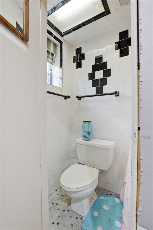 22 Burdett Road Lynn, MA 01904 - Photo 20 of 30 a white toilet sitting next to a bathroom sink and vanity