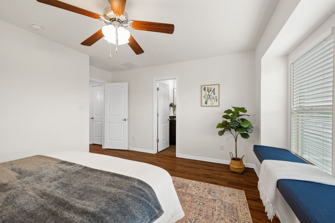 4517 Truth Way, Unit 412 Austin, TX 78725 - Photo 19 of 25 a bedroom with a bed and a chandelier