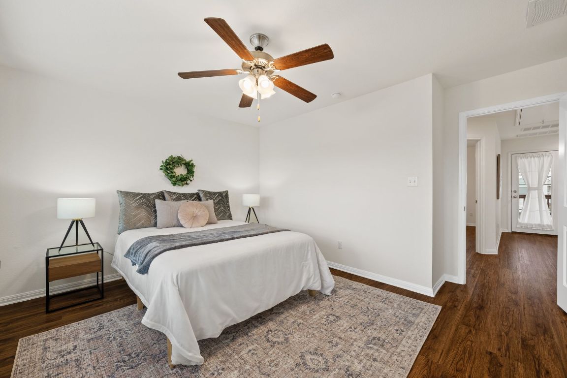 4517 Truth Way, Unit 412 Austin, TX 78725 - Photo 20 of 25 a bedroom with a bed and a ceiling fan