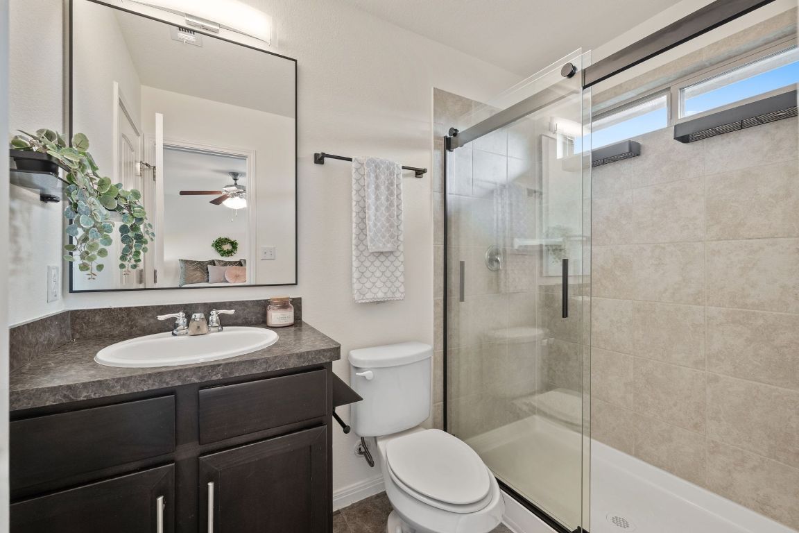 4517 Truth Way, Unit 412 Austin, TX 78725 - Photo 21 of 25 a bathroom with a sink toilet a mirror and shower