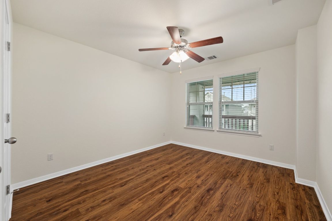4517 Truth Way, Unit 412 Austin, TX 78725 - Photo 22 of 25 a view of an empty room with wooden floor and a window