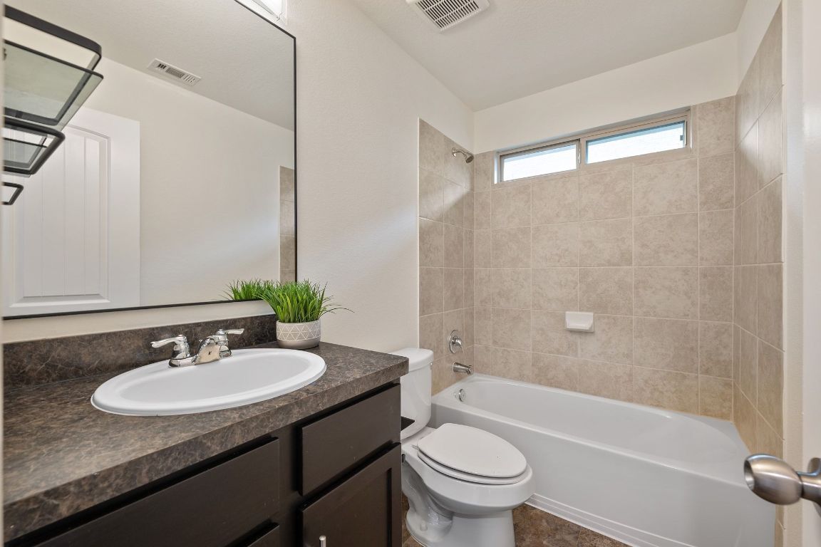 4517 Truth Way, Unit 412 Austin, TX 78725 - Photo 23 of 25 a bathroom with a granite countertop sink toilet and shower
