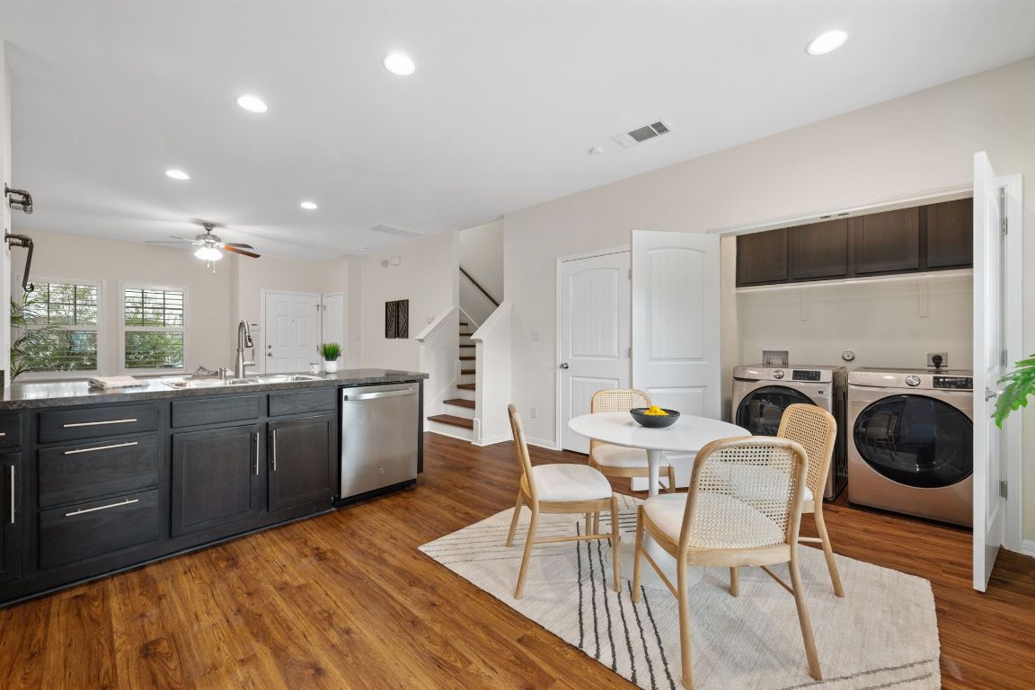 4517 Truth Way, Unit 412 Austin, TX 78725 - Photo 5 of 25 a kitchen with granite countertop a dining table chairs and white cabinets