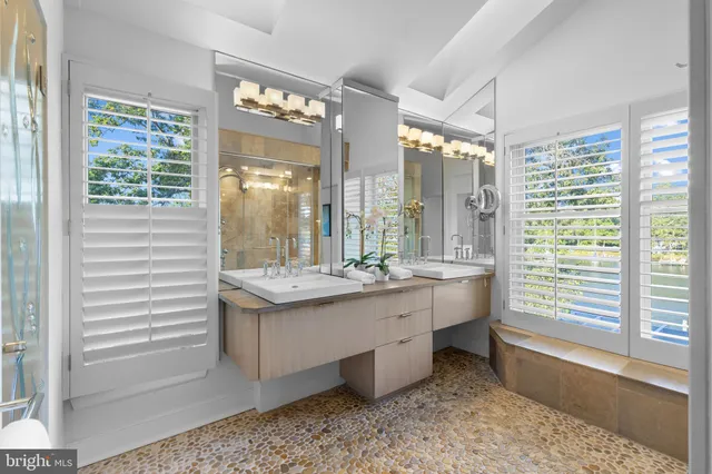 a bathroom with a granite countertop sink and a large mirror