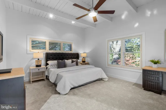 a spacious bedroom with a large bed and a chandelier