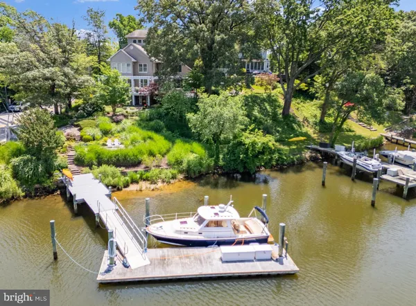 a aerial view of a house with swimming pool a yard and lake view