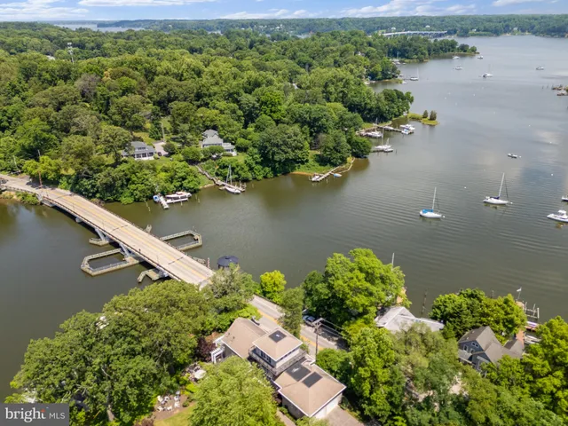 an aerial view of a house with a yard and lake view