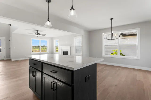 a kitchen with kitchen island a center island wooden floor and a chandelier
