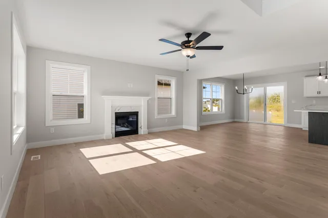 a view of an empty room with window and wooden floor