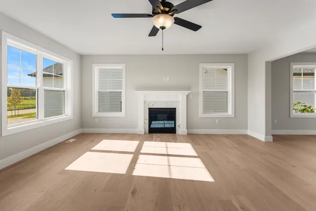 a view of an empty room with a window and fireplace