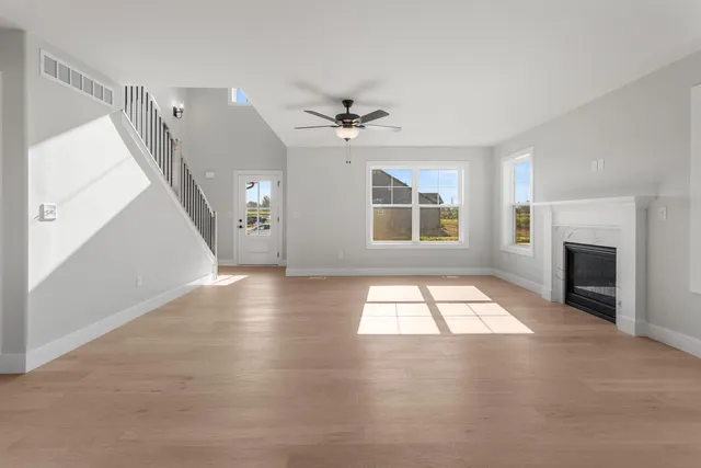 an empty room with windows and fireplace