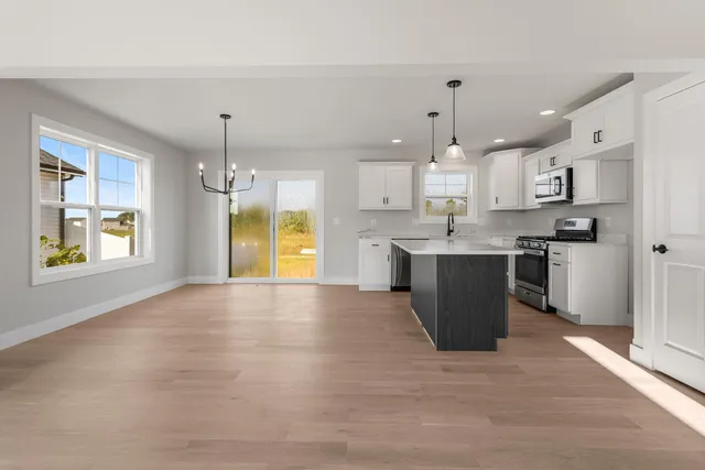 a view of kitchen with kitchen island a sink wooden floor and a counter top space