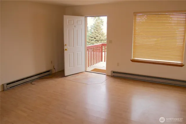 a view of a livingroom with wooden floor and a window
