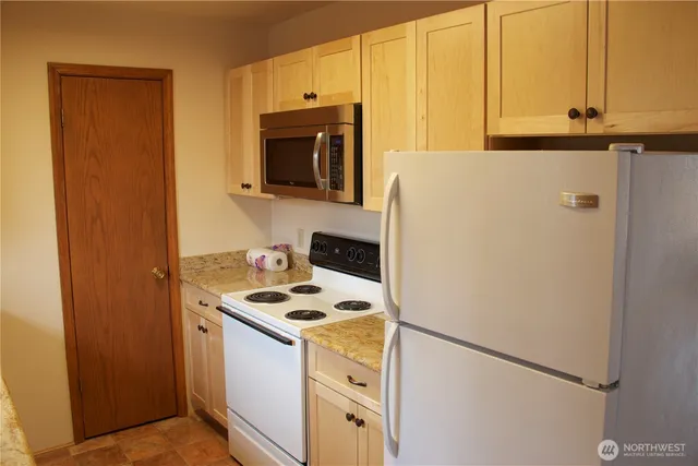 a kitchen with a refrigerator and a stove top oven