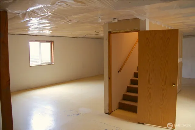 an empty room with stairs and windows