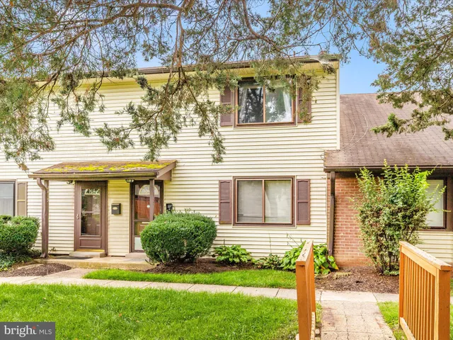 a front view of a house with a yard and plants