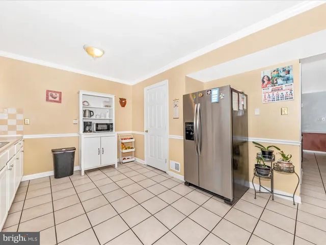 a view of kitchen with furniture and refrigerator