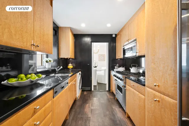 a large kitchen with stainless steel appliances granite countertop a lot of counter space and wooden floor