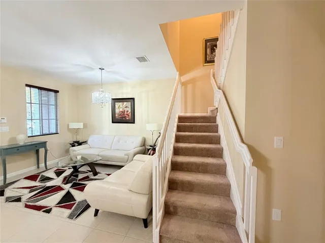 a living room with furniture and stairs