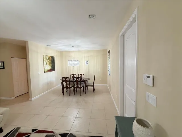 a dining room with furniture and a potted plant