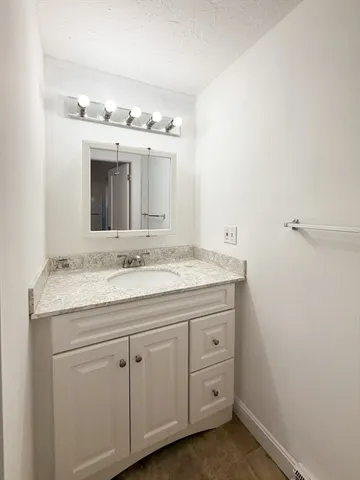 a bathroom with a granite countertop sink and a mirror