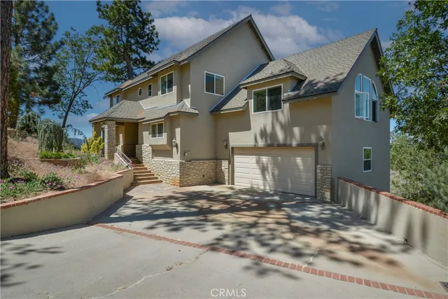 a view of a white house with large windows and a small yard