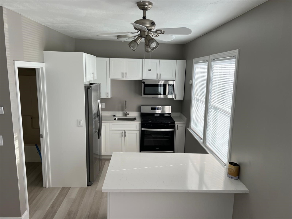 a kitchen with white cabinets and stainless steel appliances