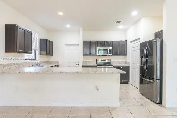 a kitchen with stainless steel appliances granite countertop a refrigerator and a stove top oven