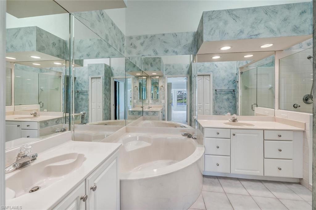 3520 Windjammer Circle, Unit 102 Naples, FL 34112 - Photo 11 of 26 a bathroom with a sink double vanity and a shower