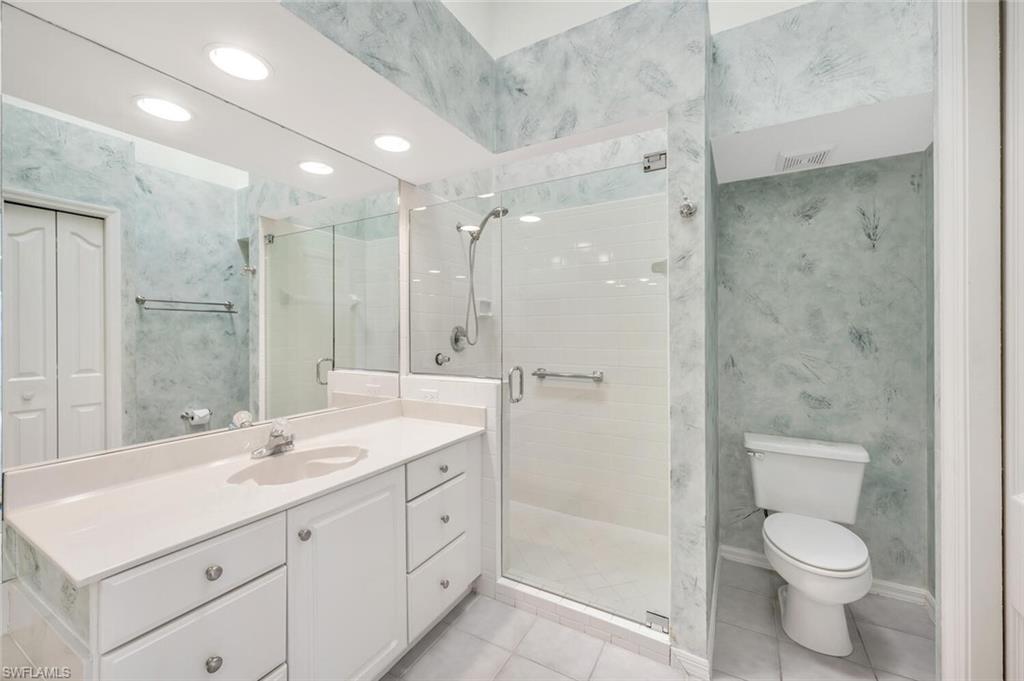 3520 Windjammer Circle, Unit 102 Naples, FL 34112 - Photo 12 of 26 a spacious bathroom with a shower sink mirror and toilet