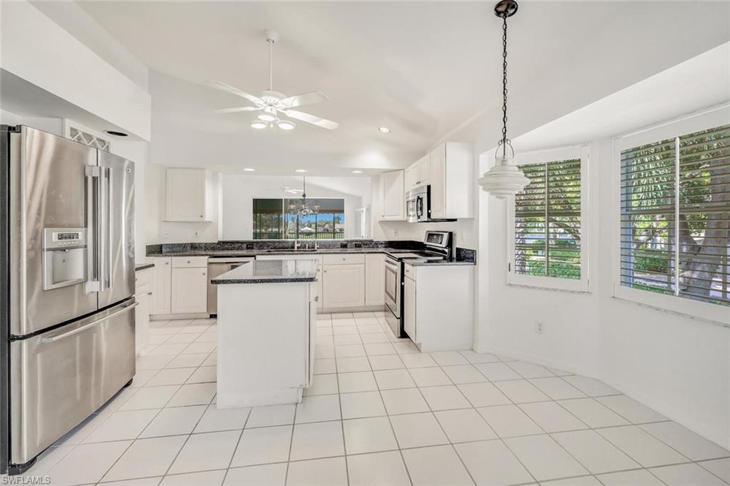 3520 Windjammer Circle, Unit 102 Naples, FL 34112 - Photo 6 of 26 a kitchen with white cabinets and refrigerator