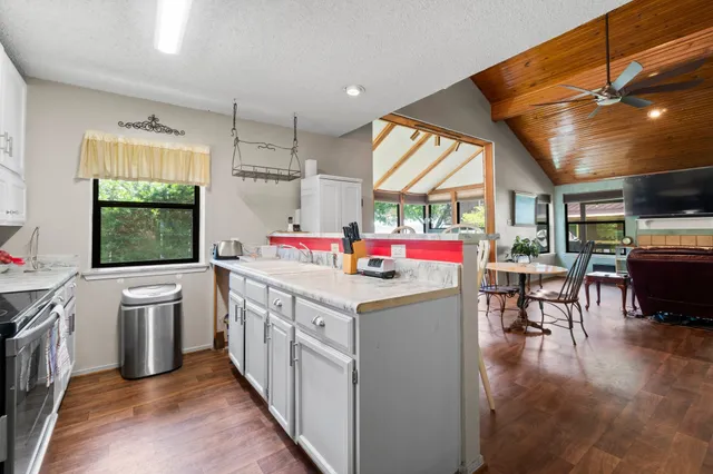 a utility room with stainless steel appliances kitchen island granite countertop a stove and cabinets