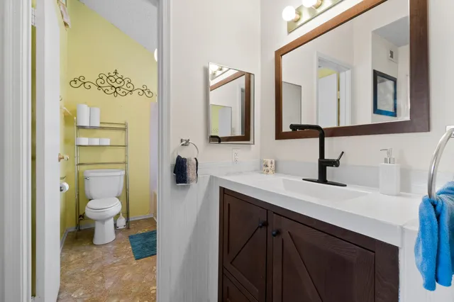 a bathroom with a toilet sink and mirror