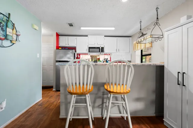 a view of a dining room with furniture wooden floor and chandelier