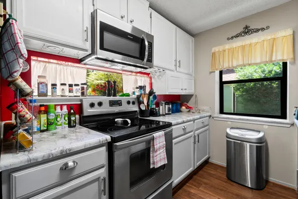 a kitchen with stainless steel appliances granite countertop a stove and a microwave
